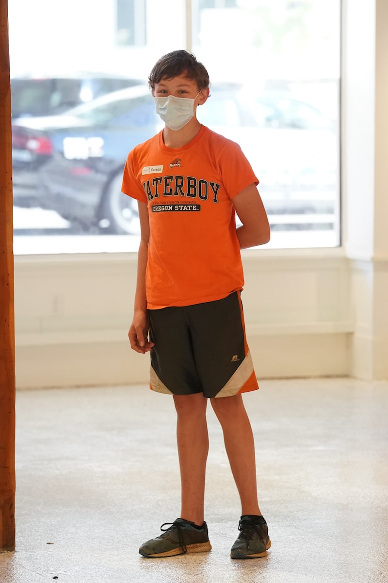 a boy in orange standing