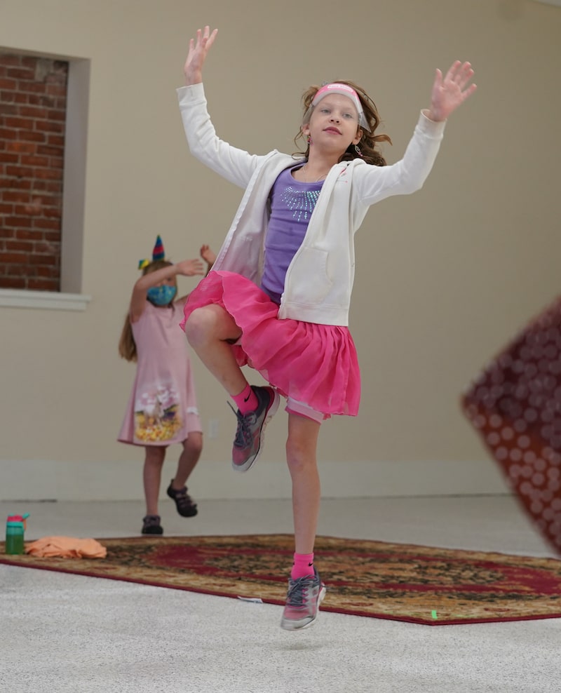 girl in a pink skirt jumping with joy