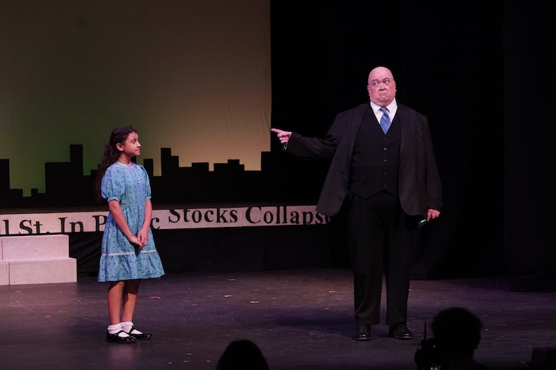 Annie and Mister Warbucks look at each other for across the stage